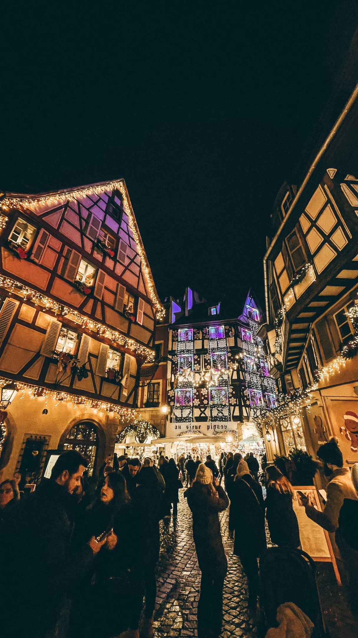 Christmas market in Alsace, lit alley and half-timbered houses at night