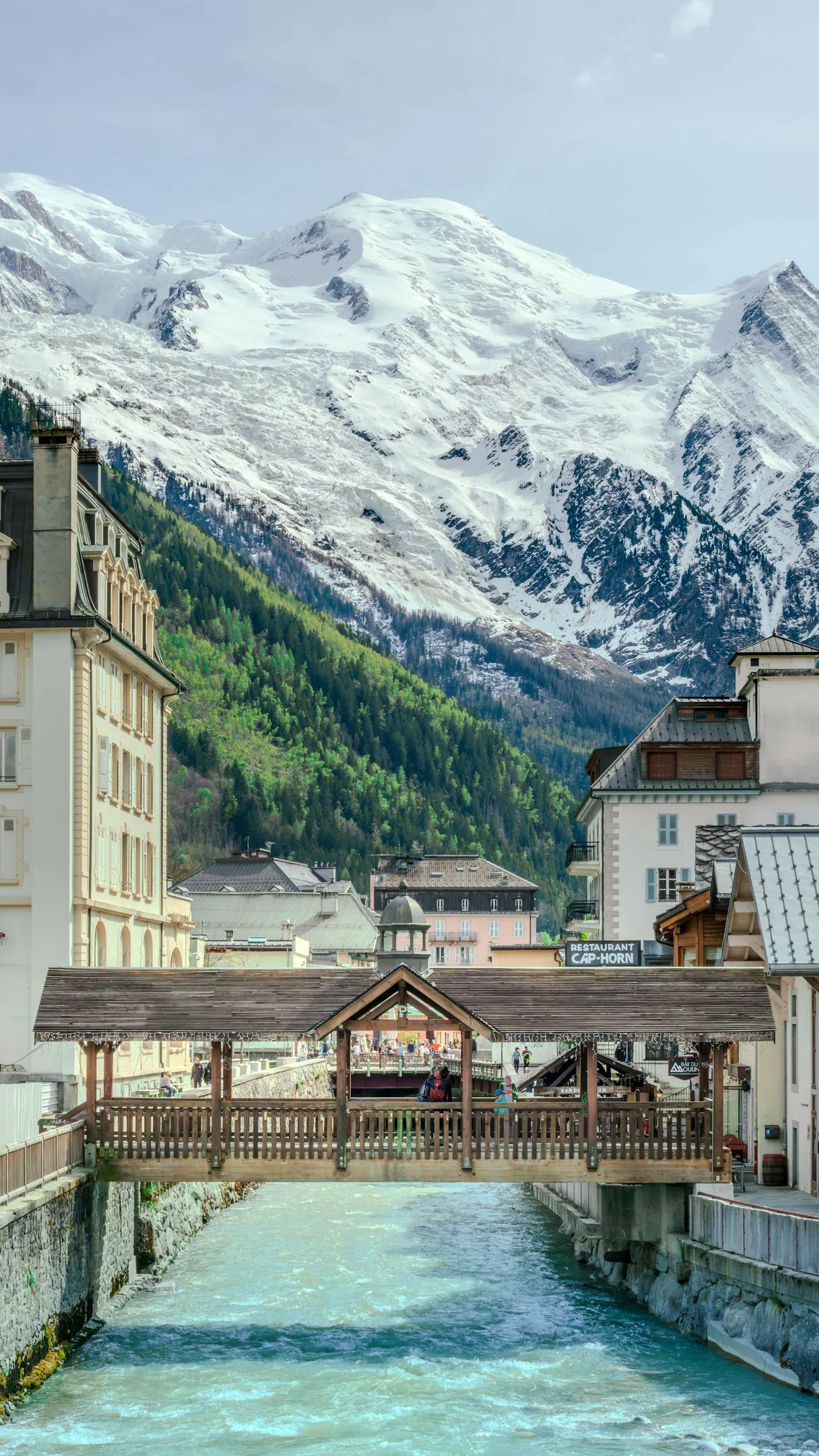 A bridge over a river in Chamonix with Mont Blanc in the background