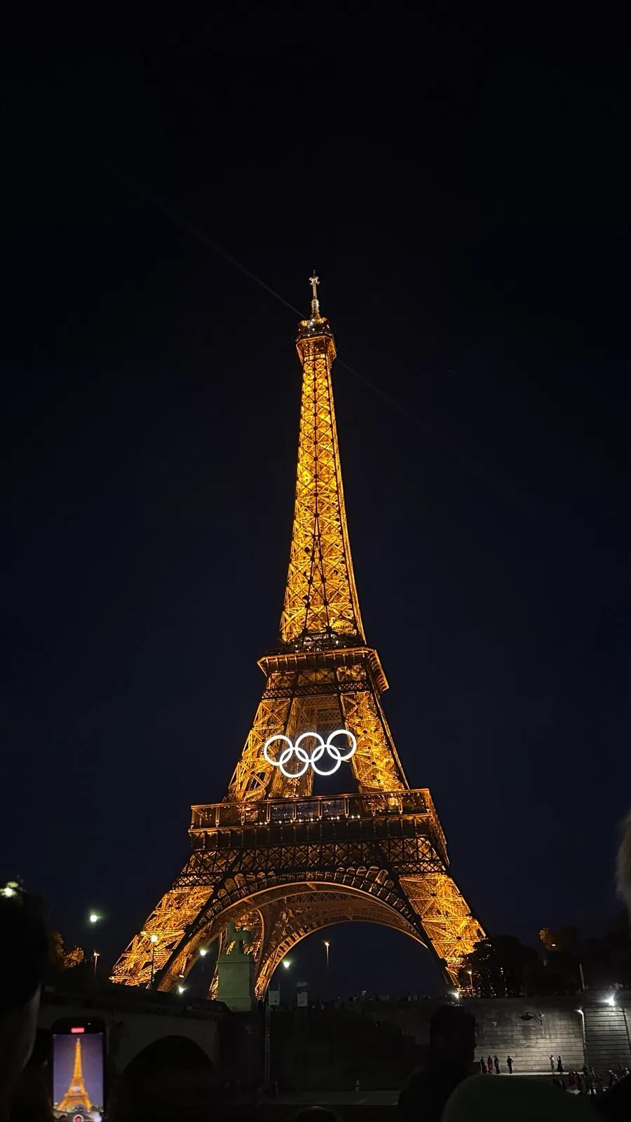 The Eiffel Tower lit up at night as seen from a bateau-mouche on the Seine
