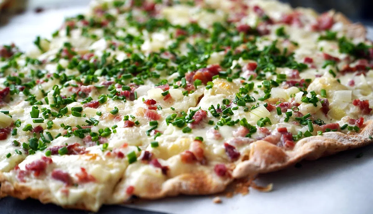 Alsatian flammekueche (tarte flambée): thin crust, cream, onions and bacon bits
