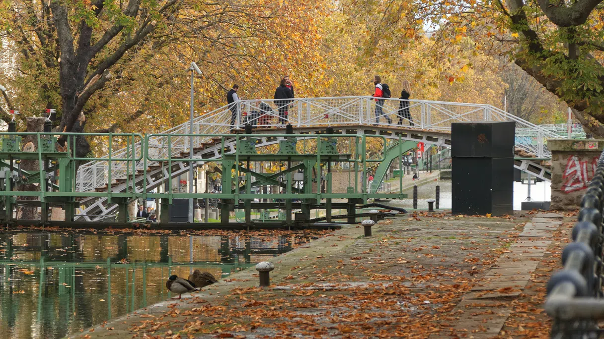 Passersby crossing a footbridge on the Canal Saint-Martin in Paris