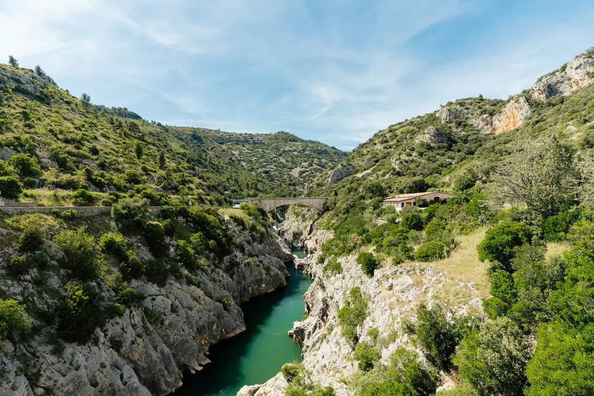 Turquoise water below a rocky bridge in the Hérault gorge