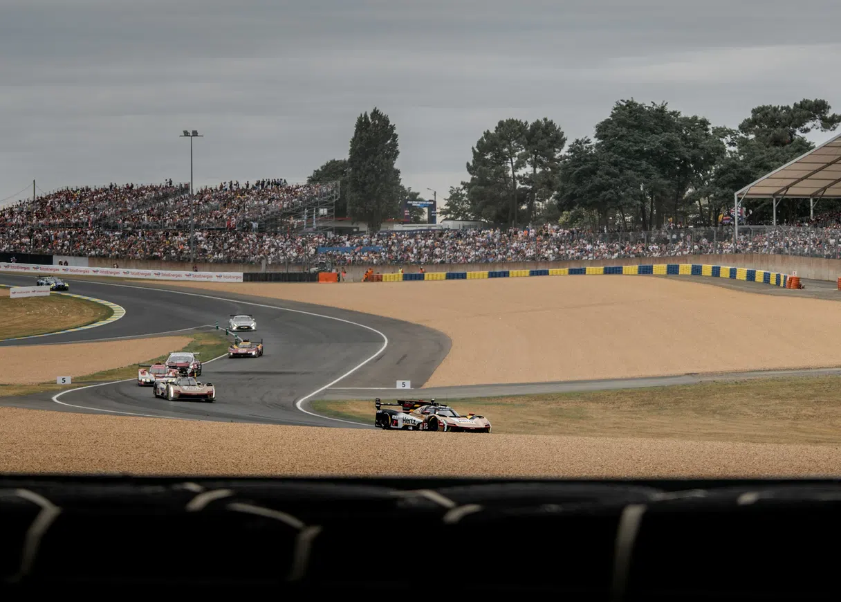 An endurance racing car on the circuit at Le Mans in front of full grandstands