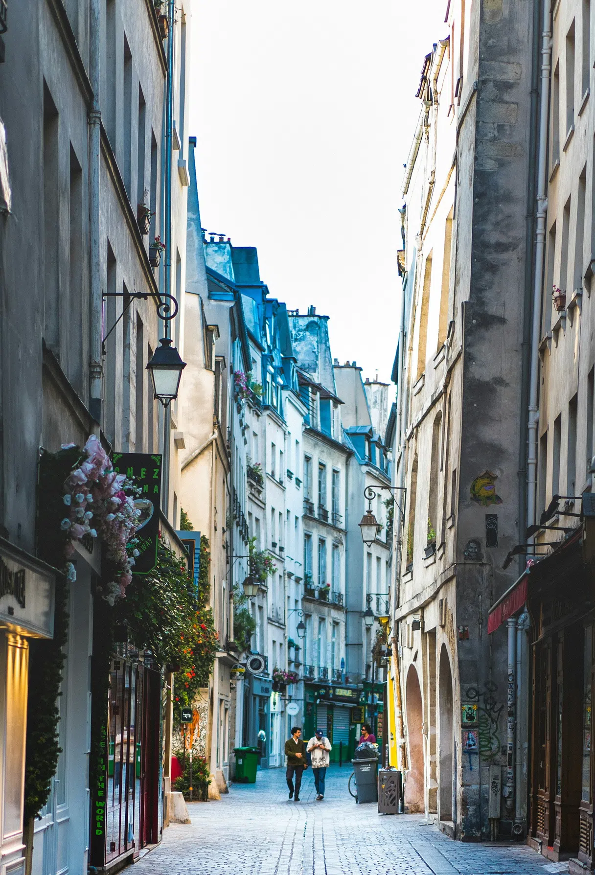 Passersby in a typical street of the Marais in Paris